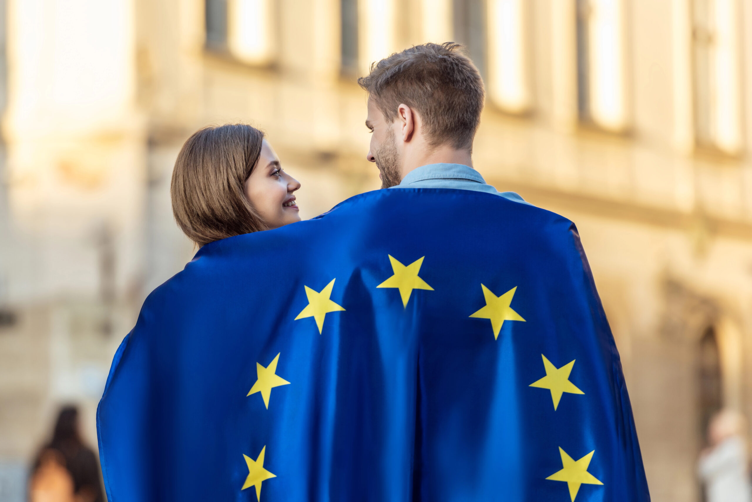 Пара стоїть, загорнувшись у прапор Європейського Союзу