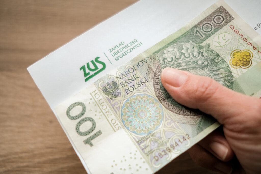 Банкнота й монети на документі з логотипом ZUS