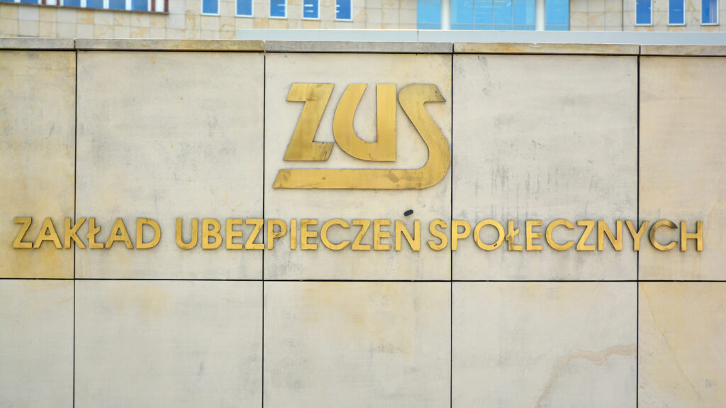 Вивіска ZUS на кам’яній стіні будівлі