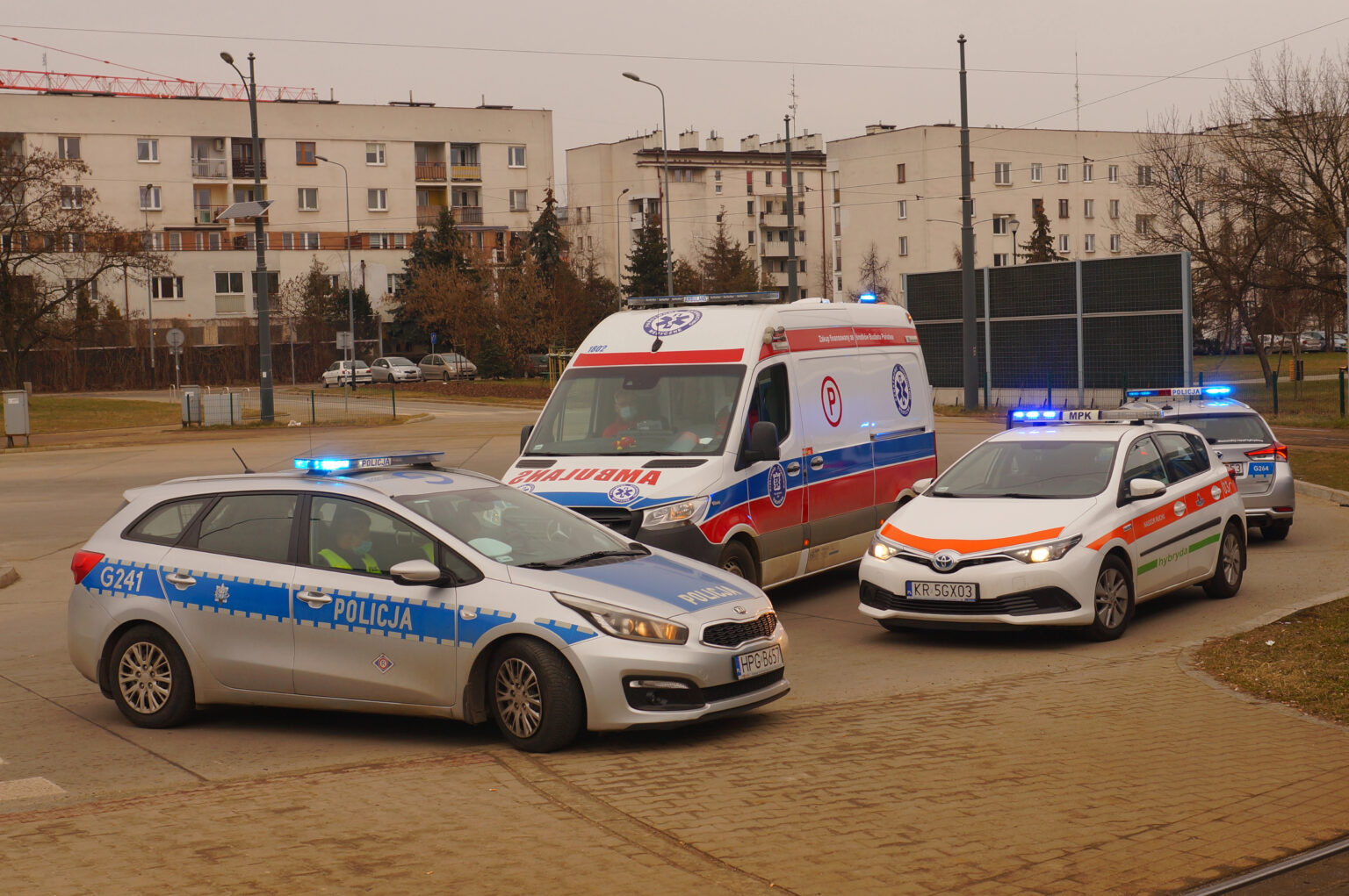Поліцейські машини та автомобіль швидкої допомоги біля будівлі