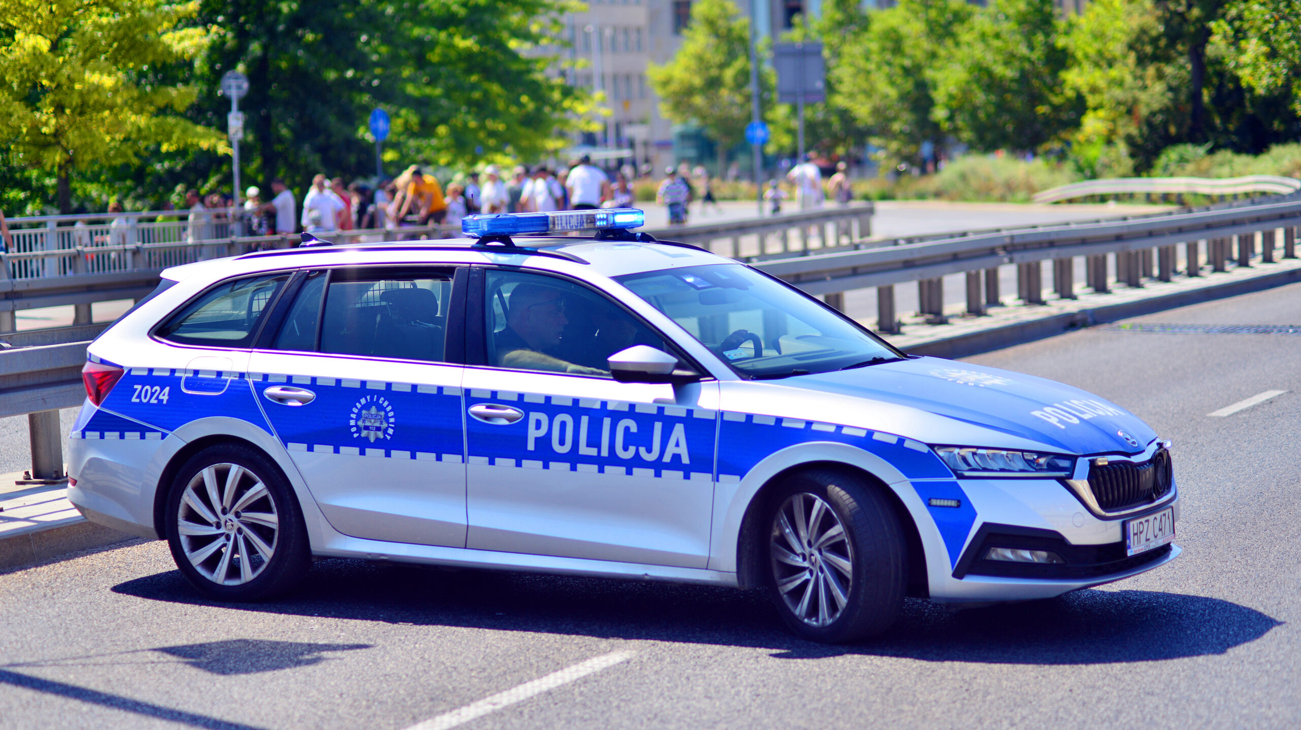 Патрульний автомобіль POLICJA на міській дорозі, вигляд збоку й спереду
