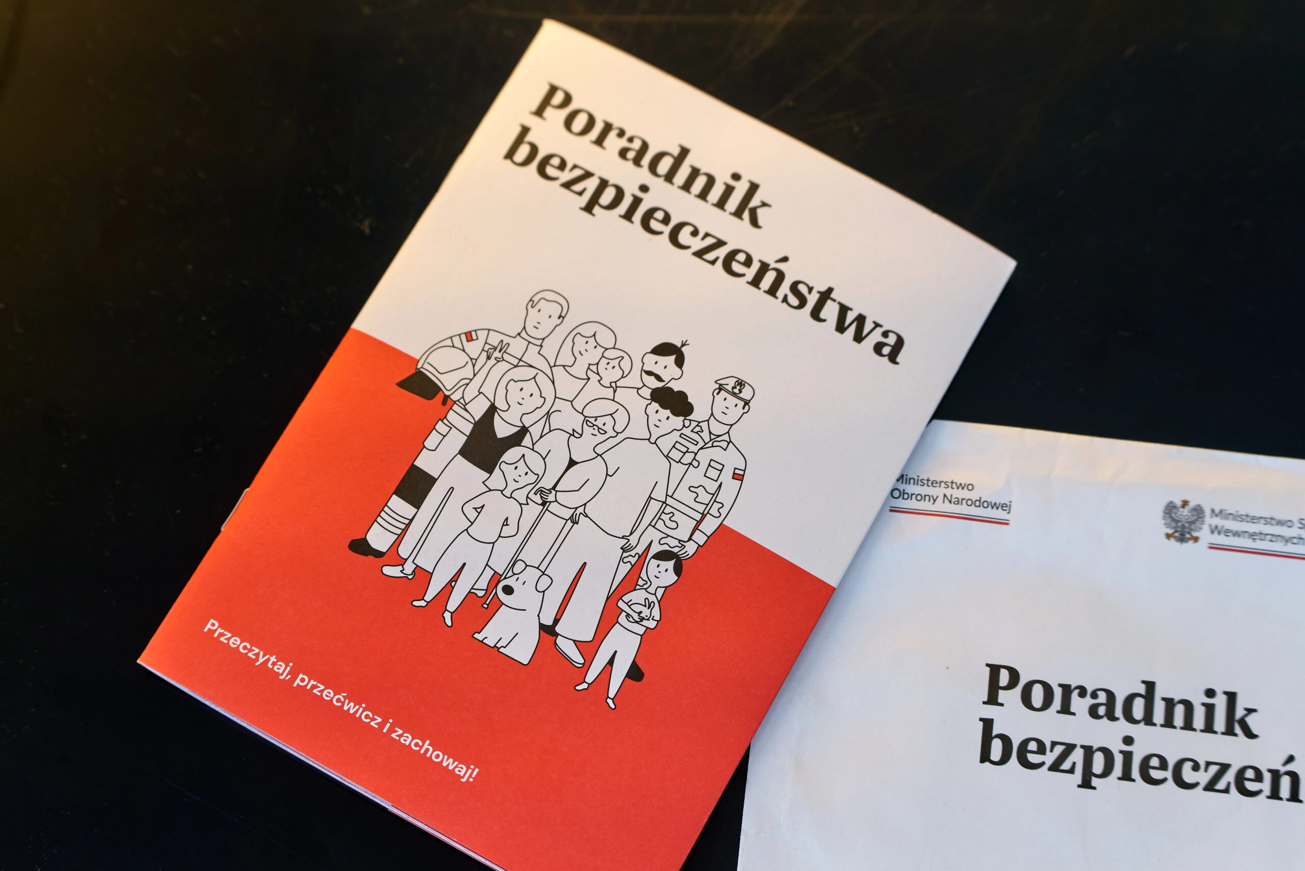 Обкладинка посібника Poradnik bezpieczeństwa на темному тлі