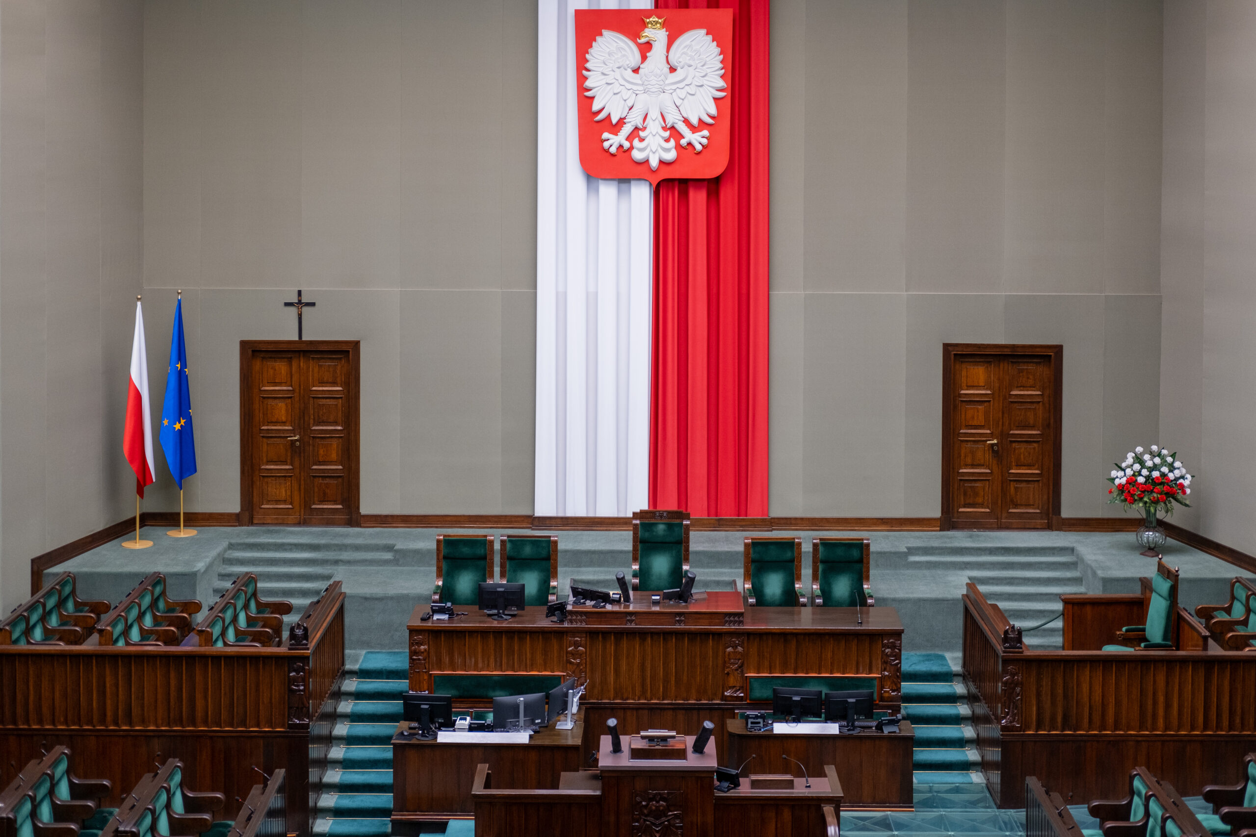 Зала засідань із польським гербом, прапорами Польщі та ЄС