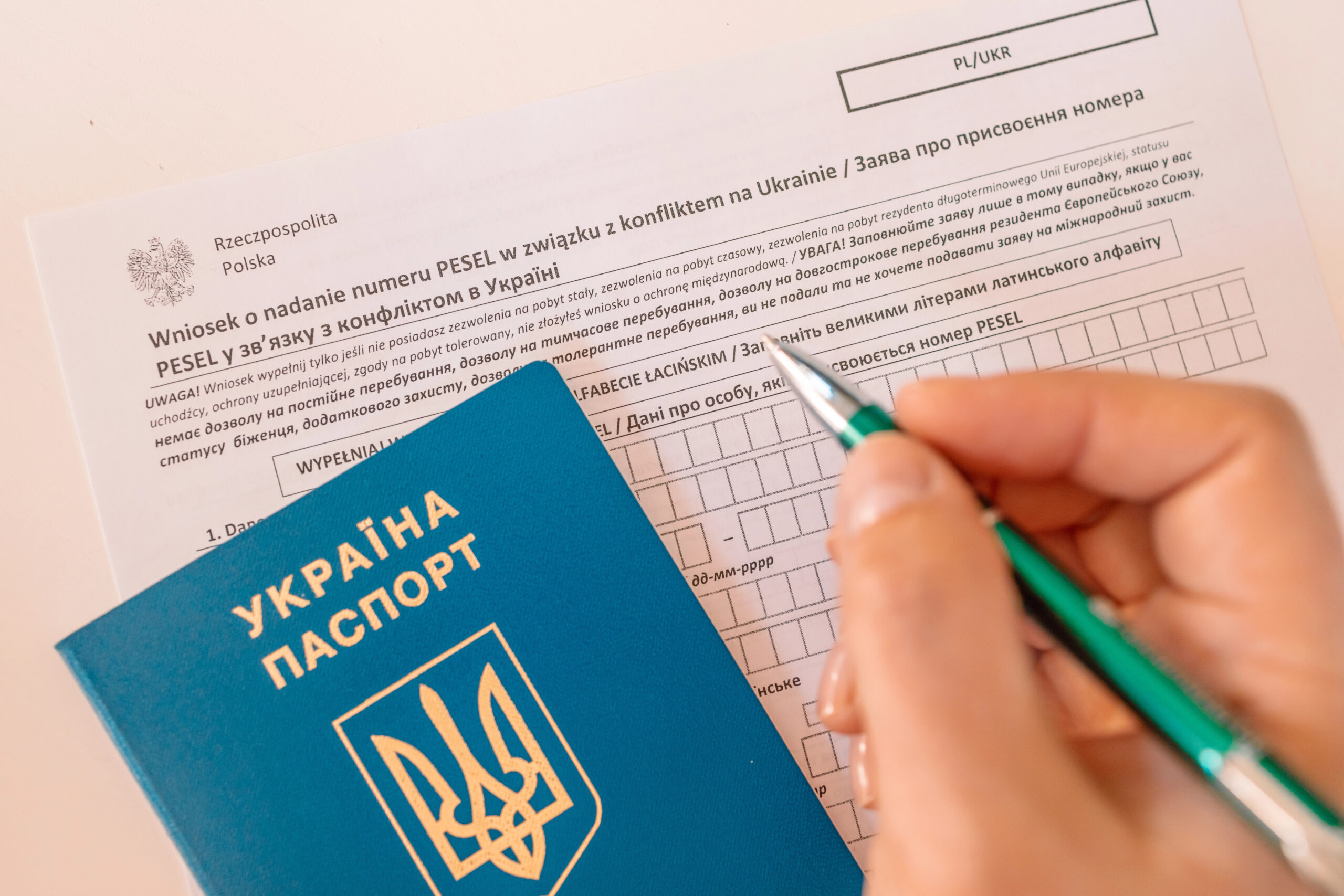 Заповнення заяви на PESEL поруч з українським паспортом