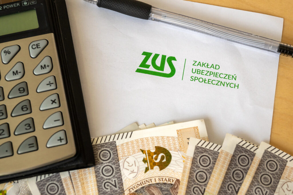 Калькулятор, документ із логотипом ZUS і польські банкноти