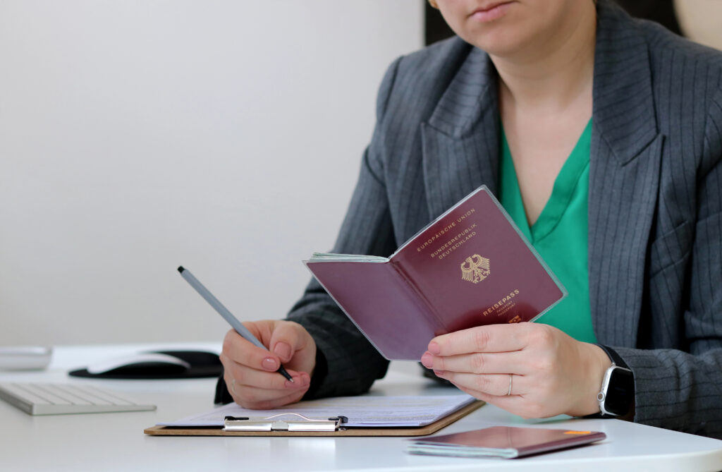 Працівниця перевіряє німецький паспорт під час оформлення анкети