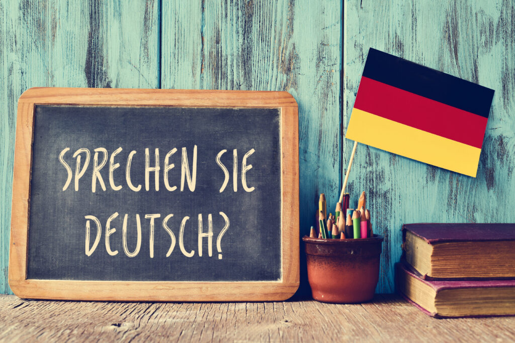 Дошка з написом Sprechen Sie Deutsch поруч із прапорцем Німеччини